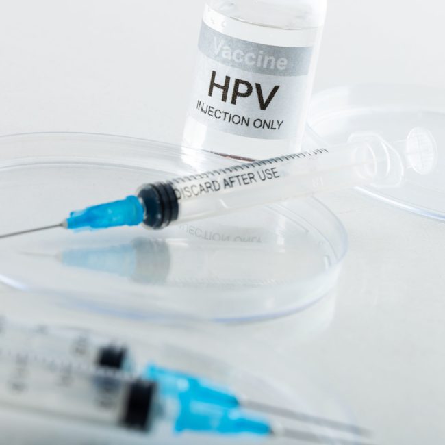 Composition of hpv vaccine vial and syringes on white background with copy space. Medicine, medical services, healthcare and health awareness concept.